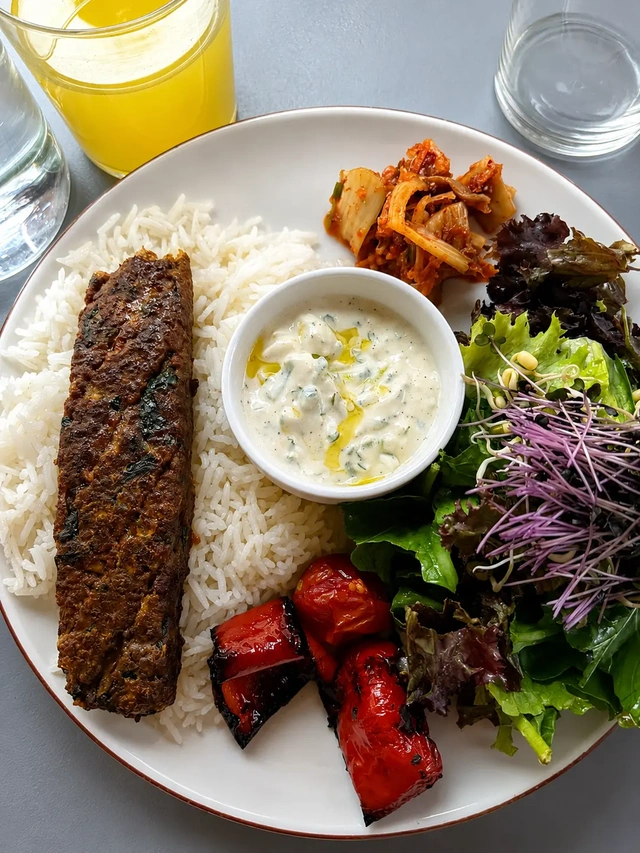 vegan restaurants in Istanbul – colorful vegan plate with rice, plant-based kofta, salad, roasted vegetables, kimchi, and creamy sauce.
