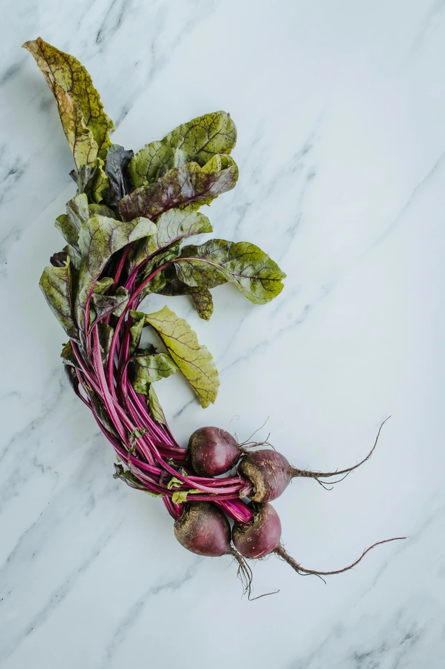 Beetroot on white marble, with whole fresh beets displayed in a clean minimal composition for a guide on how to cook beetroot.