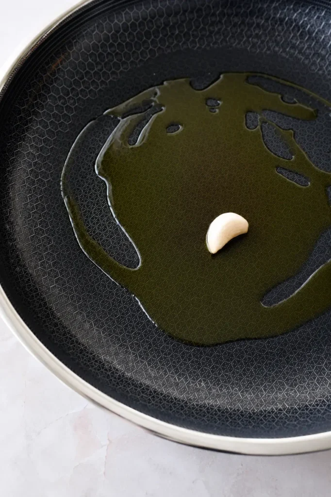 Sauteed eggplants with garlic and herbs cooking step with olive oil and garlic in a nonstick pan.