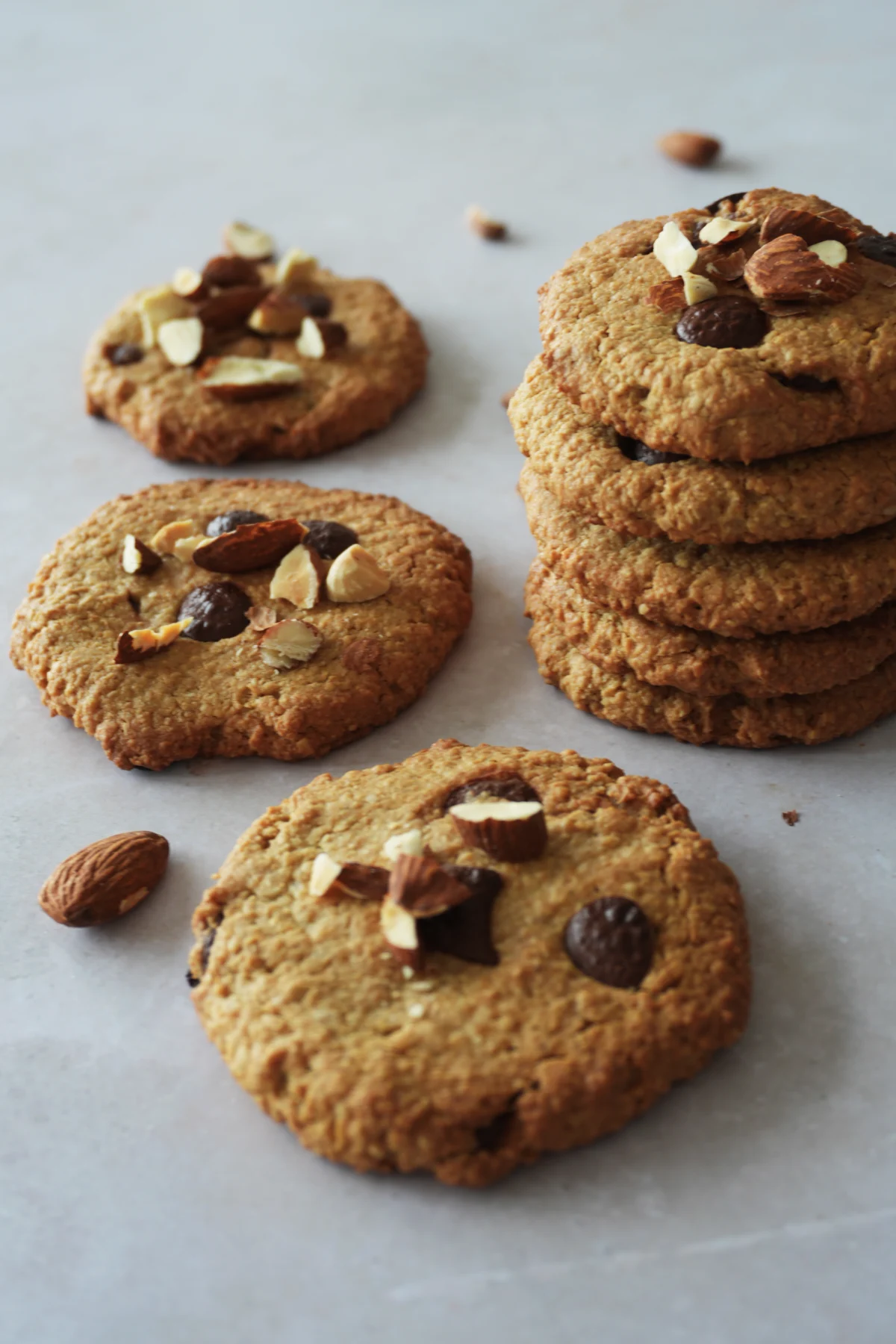 Vegan gluten-free oat cookies arranged on a table, with a chewy texture, crisp edges, and a soft homemade look.