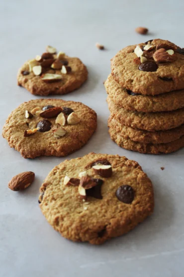 Vegan gluten-free oat cookies arranged on a table, with a chewy texture, crisp edges, and a soft homemade look.
