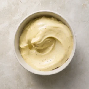 Vegan mayo in a small bowl with a smooth, creamy texture and soft overhead light.