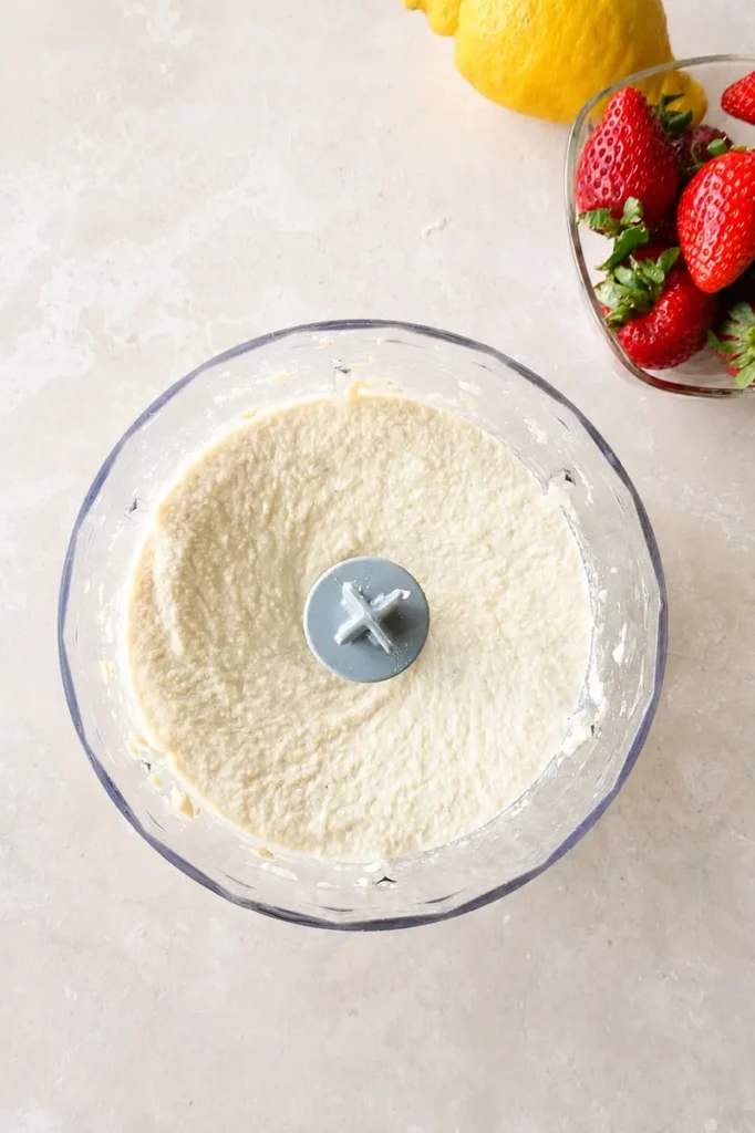 Vegan strawberry cheesecake filling blended until smooth and creamy in a food processor.