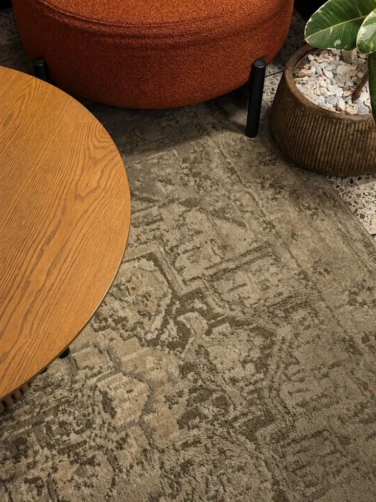 Interior detail of Mallow restaurant in London, with patterned flooring, a table, and a textured rug in a warm modern setting.