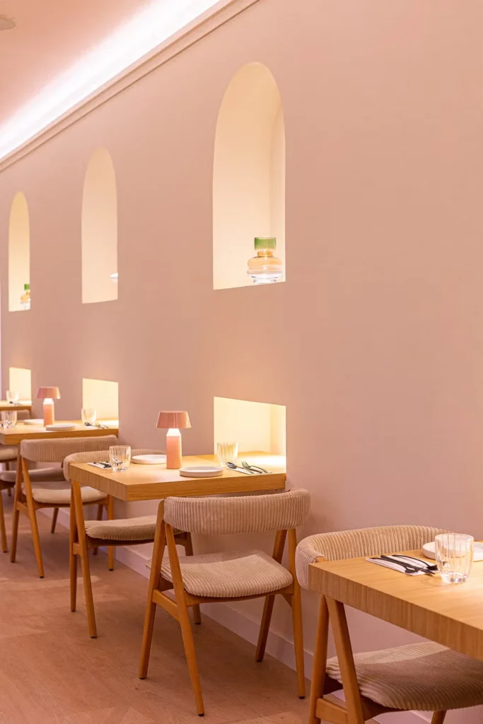 vegan restaurants in Madrid, elegant industrial-style interior at Mudra with exposed brick walls, warm lights, and dark wooden tables.