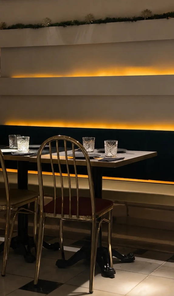 Vegan restaurants in Madrid: warm interior of Choose restaurant with exposed brick walls, wooden tables, vintage industrial lighting, and an elegant intimate atmosphere.