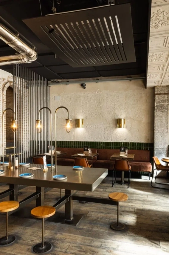 Vegan restaurants in Madrid, warm interior of Grosso Napoletano pizzeria with rustic tables, soft lighting, and a casual Italian dining atmosphere.