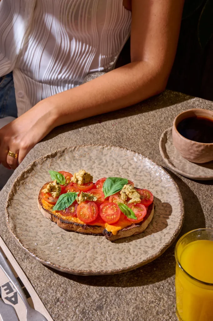 Vegan restaurants in Madrid, bruschetta served on a wooden table at Honest Green, with fresh toppings and a casual plant-forward setting.