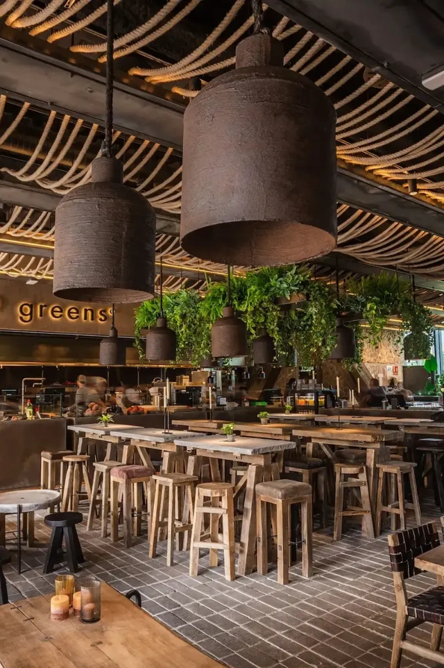 Vegan restaurants in Madrid, warm brown designer interior at Honest Green with modern lighting, natural textures, and a stylish healthy dining atmosphere.