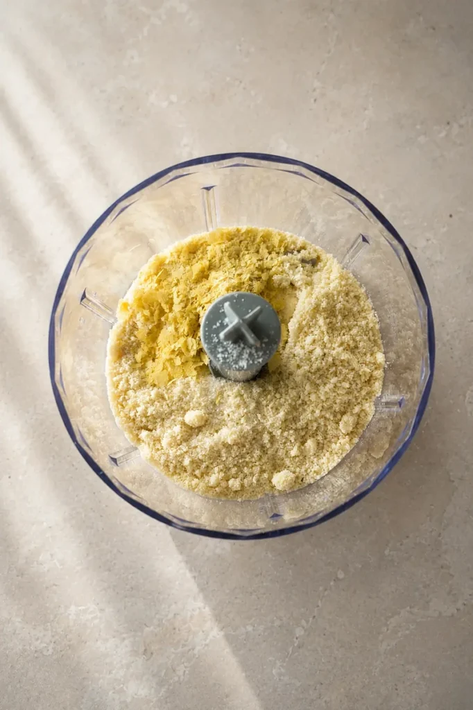 Vegan ricotta mixture in a food processor with almond flour and nutritional yeast before blending