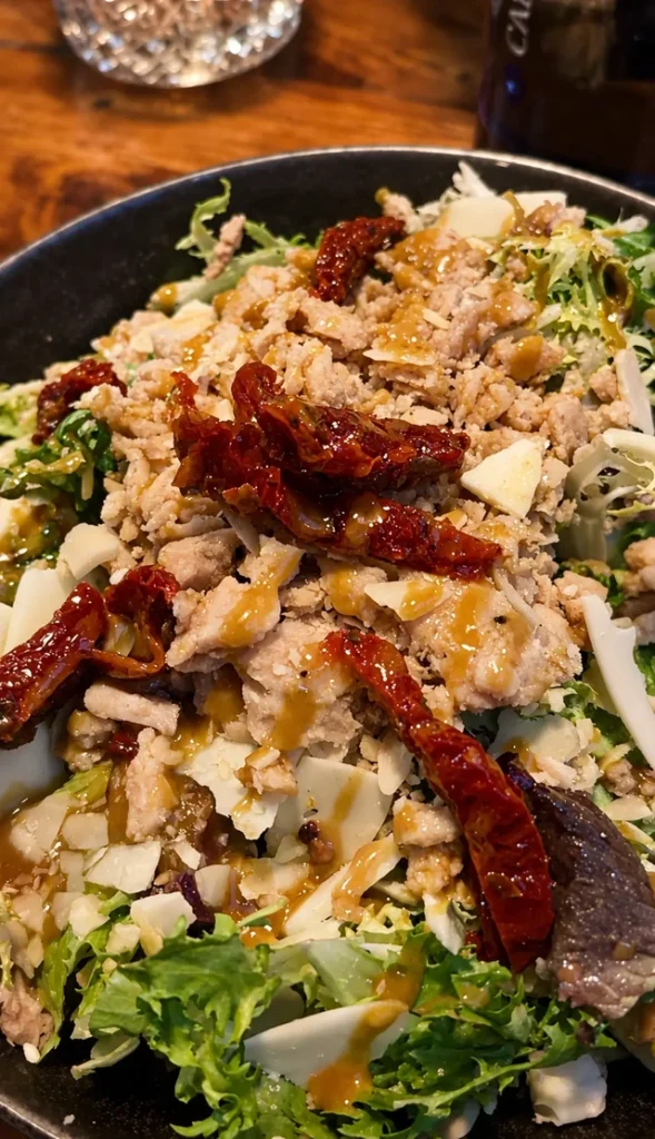 Vegan restaurants in Madrid guide with a close-up of a colorful vegan salad topped with plant-based protein, sun-dried tomatoes, and dressing.