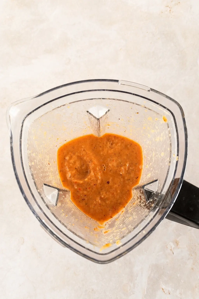 Vegan gazpacho blended in a blender with a rustic orange texture before serving