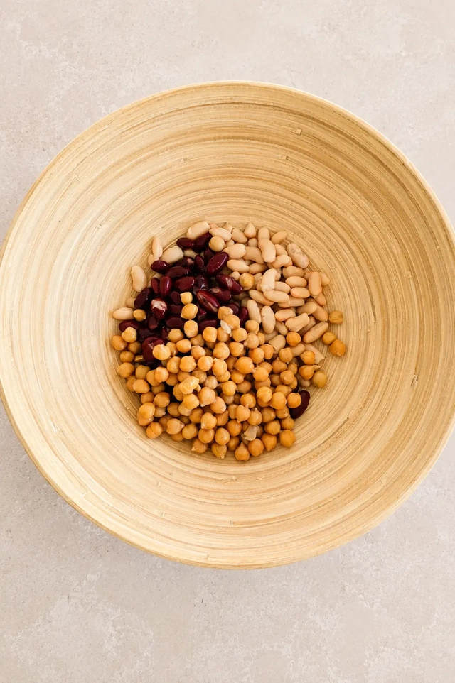 Mixed beans with chickpeas, cannellini beans, and kidney beans in a bamboo bowl for a high-protein vegan bean salad.