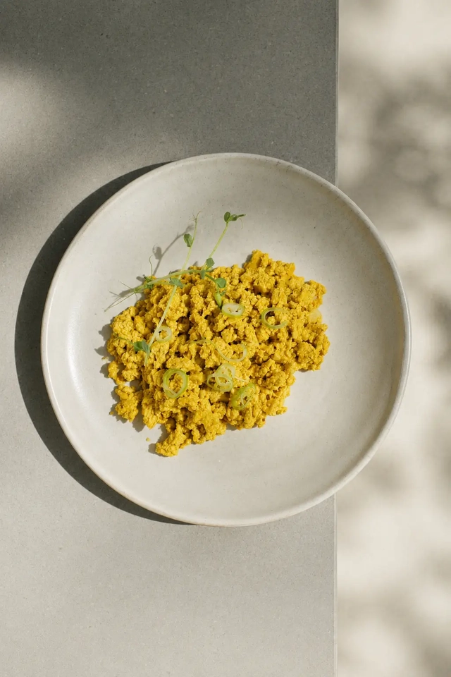 Vegan egg substitutes — silken tofu scrambled eggs with kala namak served in a white bowl