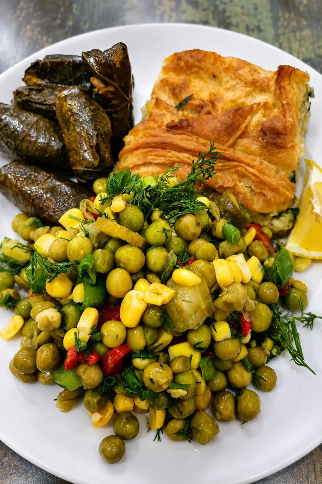istanbul vegan restaurants guide with a colorful traditional vegan plate from Vegan Istanbul, featuring stuffed vine leaves, vegetable salad, herbs, and savory Turkish-style dishes.