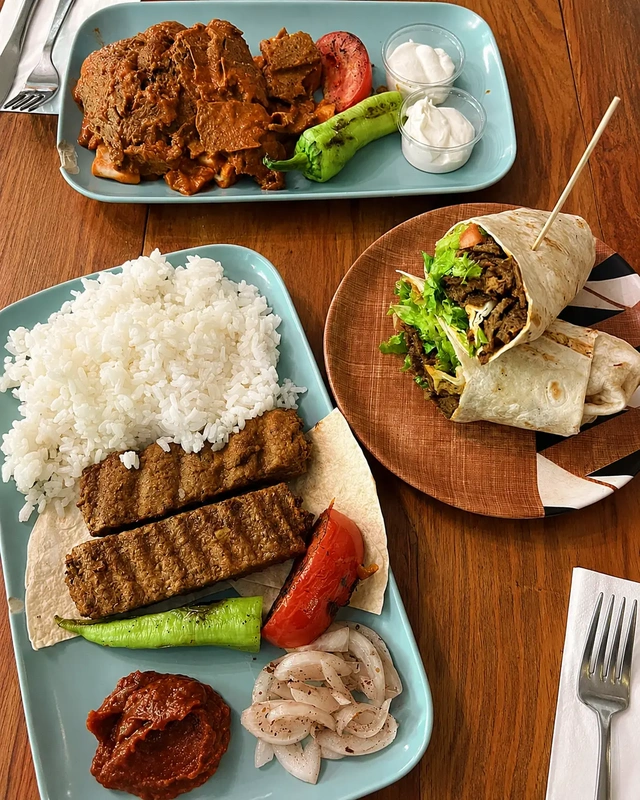 Istanbul vegan restaurants: colorful vegan plates at Vegan Regime, with rice, plant-based kebab, grilled vegetables, sauces, and a wrap on a wooden table.
