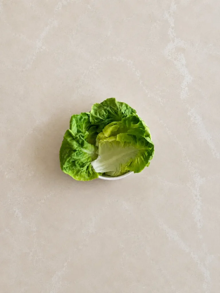 Vegan Waldorf Salad lettuce leaves served whole in a small bowl, ready to use as a crisp base or edible cups for the salad.