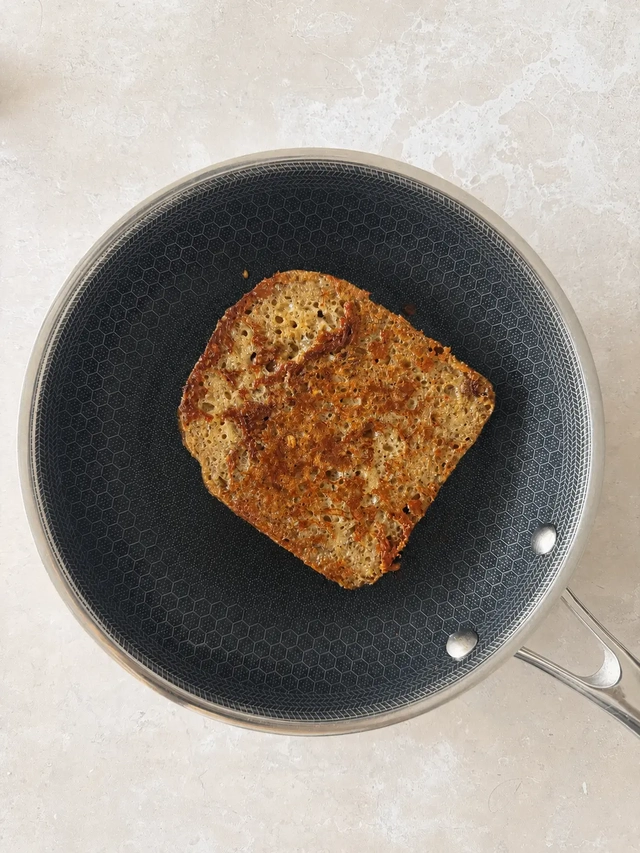 Golden-brown vegan buckwheat French toast in a non-stick frying pan after cooking, photographed from above.