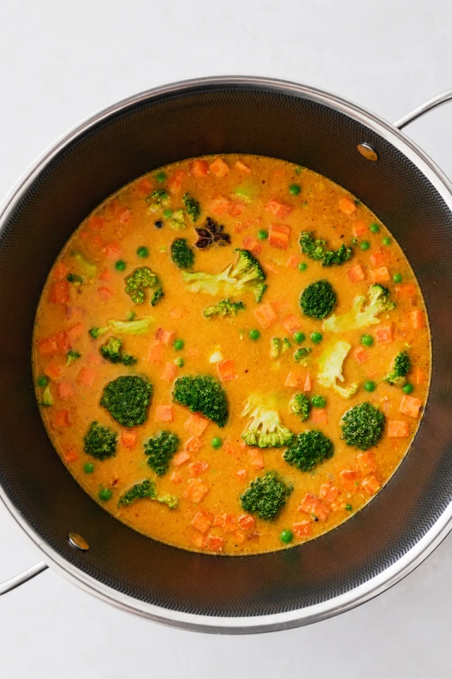 What I eat in a day as a vegan dinner with homemade vegetable korma made with broccoli, carrots, peas, and aromatic spices.