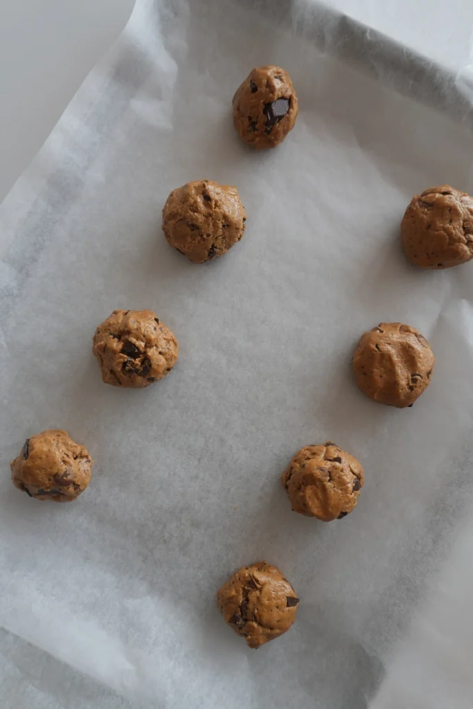 Gluten-free cookie dough mixed by hand with a spatula until thick and creamy for eggless chocolate chip cookies.
