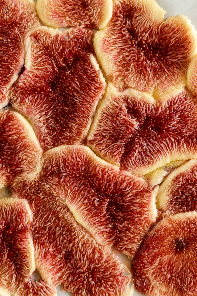 Close-up of pressed fresh fig slices forming a thin layer for fig carpaccio.