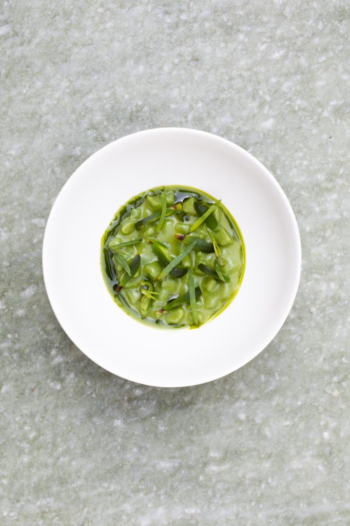 dish at Venissa restaurant in the Venetian Lagoon, featuring green vegetables and herbs served in a white bowl.