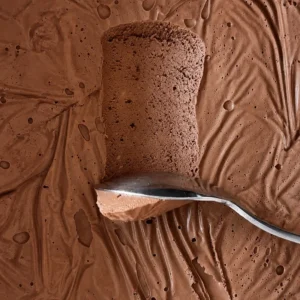 Close up of silken tofu chocolate mousse with a spoon scooping through its thick, airy and creamy texture.