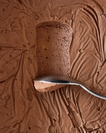 Close up of silken tofu chocolate mousse with a spoon scooping through its thick, airy and creamy texture.