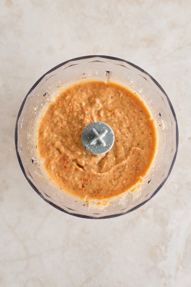 Creamy white bean and roasted tomato spread blended until smooth, ready to serve underneath vegan eggplant schnitzel.
