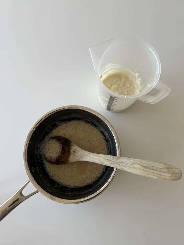 Soy milk and agar agar mixture for vegan panna cotta in a saucepan, with the plant based yogurt and mascarpone mixture ready to be combined.