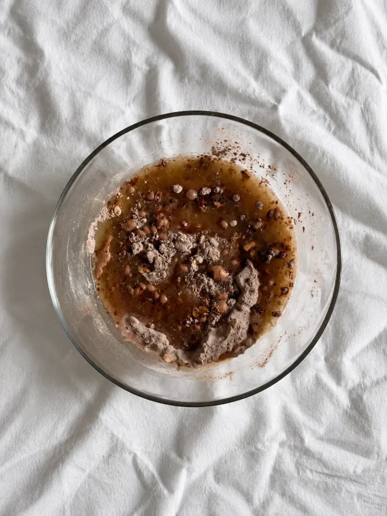 Chocolate cake batter base for vegan chocolate pear cake in a glass bowl, before being fully mixed.